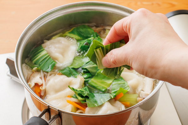 チンゲン菜の葉を加えて煮立たせ、塩、こしょうで味をととのえ、ごま油を加える。